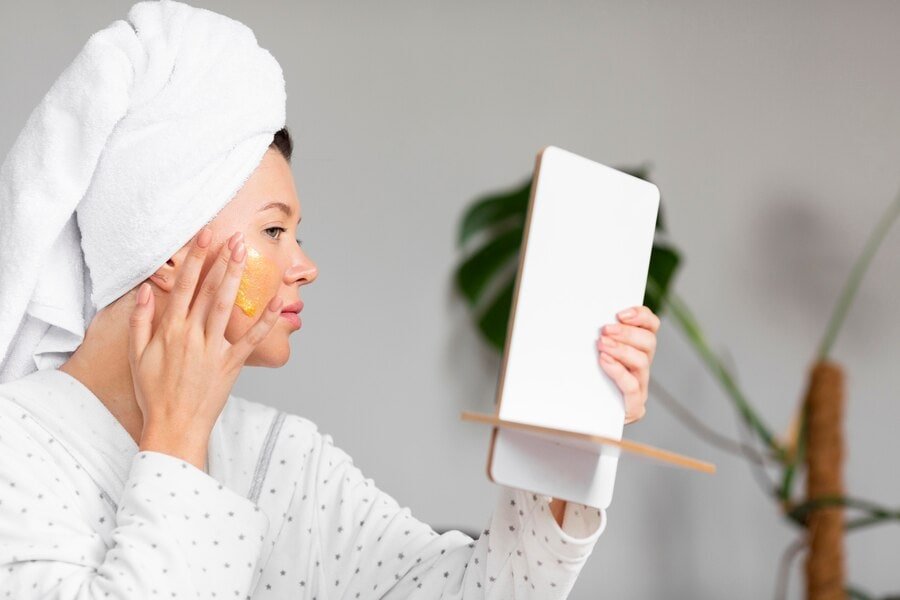 side-view-woman-bathrobe-applying-skincare-with-towel-head_23-2148655830